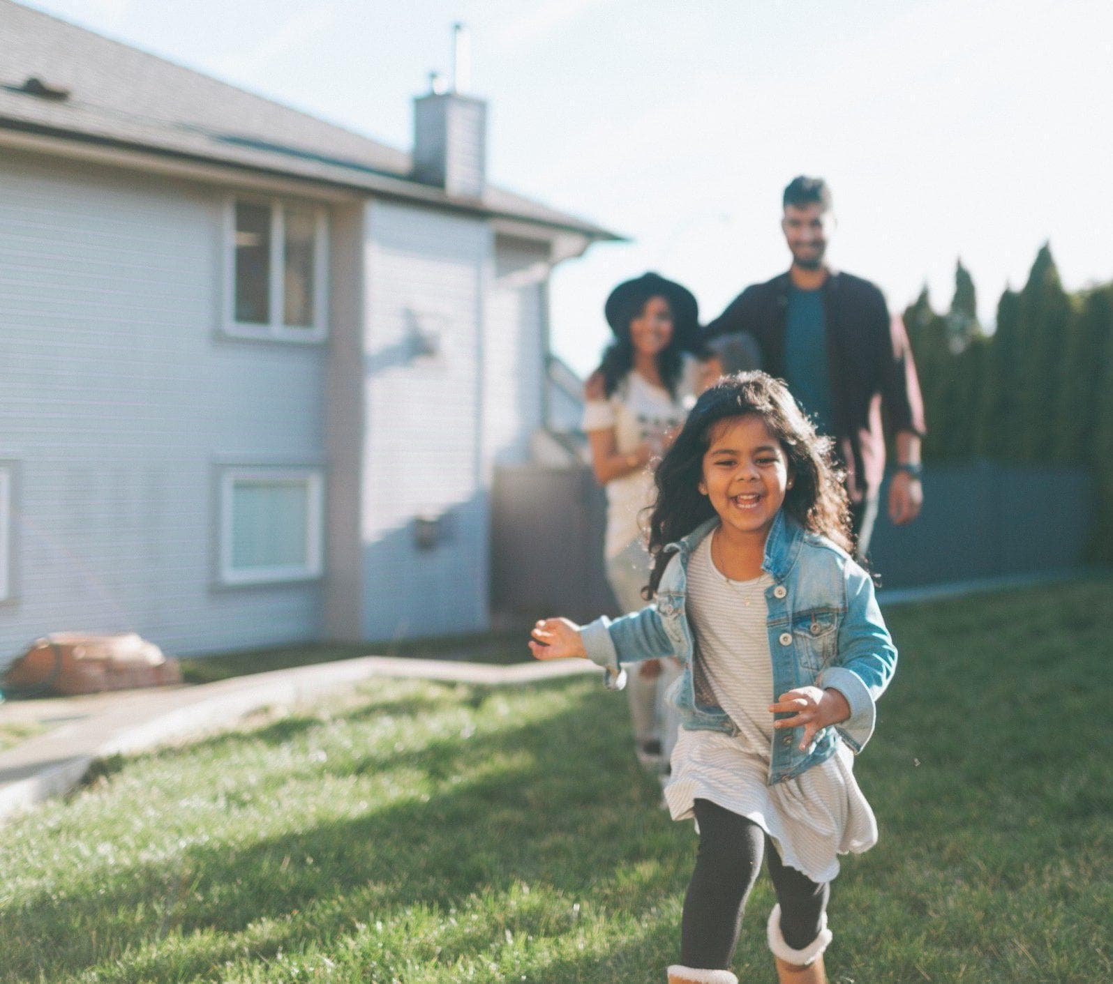 A little girl running in front of her parents