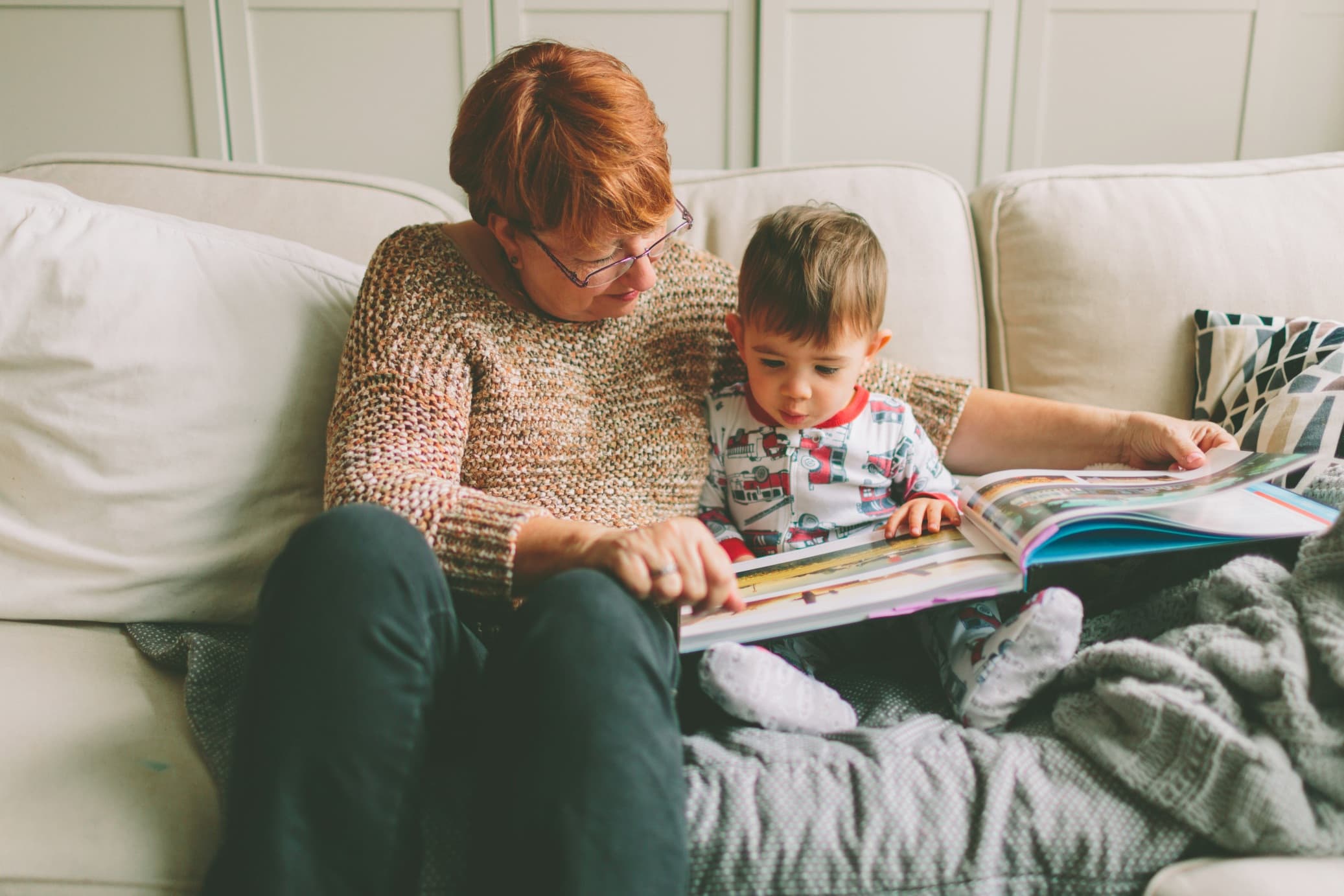 A grandmother reading to her grandchild